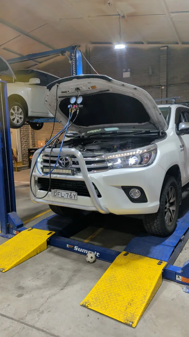 Air-con regas on a Toyota HiLux up on the hoist